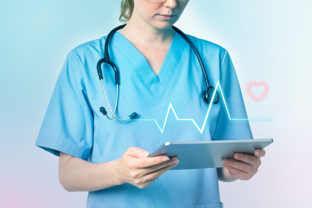 Imagem de uma profissional de saúde portando um estetoscópio e olhando para um tablet. Apenas a parte inferior do resto é exibida